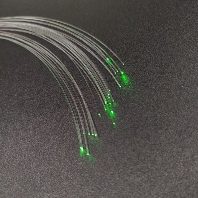 Bare DB-400 PMMA fiber strands glowing green at the ends