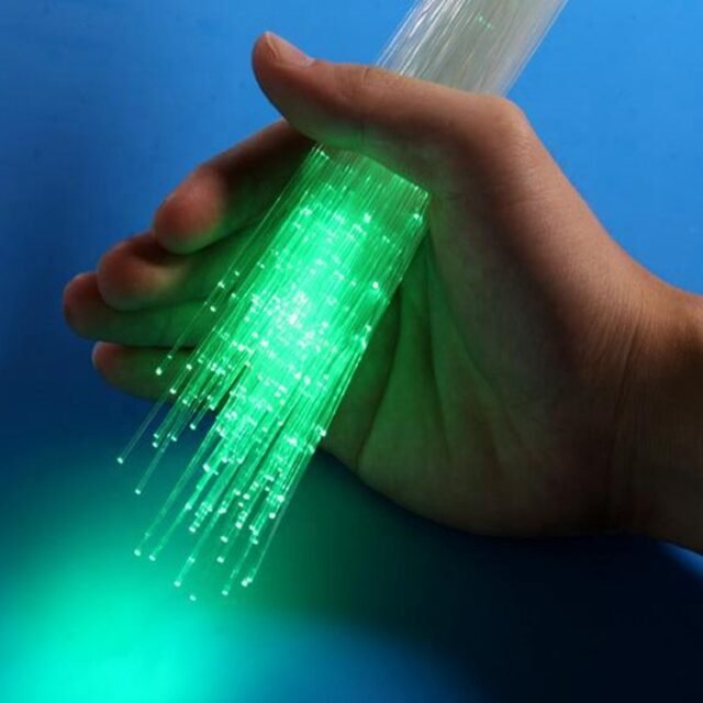 Hand holding a bundle of TB-500 PMMA fiber glowing green at the ends