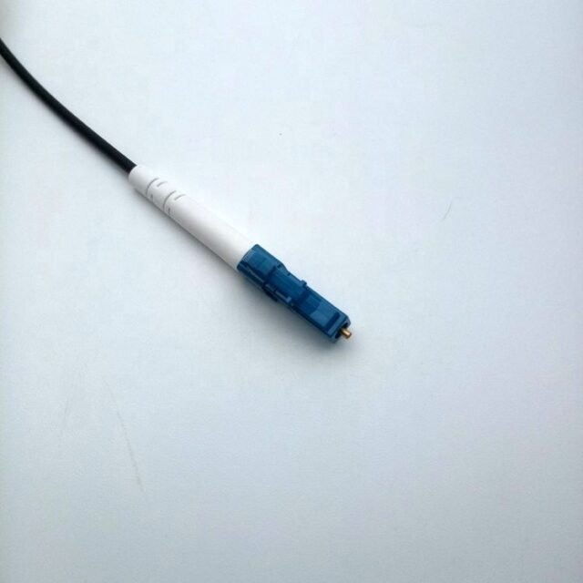 Detail of blue LC/UPC connector on black cable with white boot