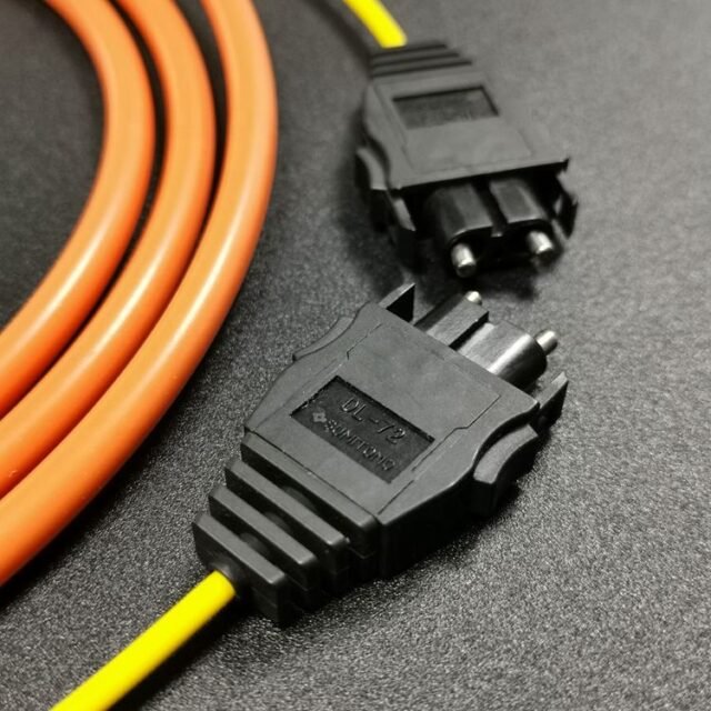 Close-up of black DL-72 SUMITOMO duplex connector on orange/yellow H-PCF cord