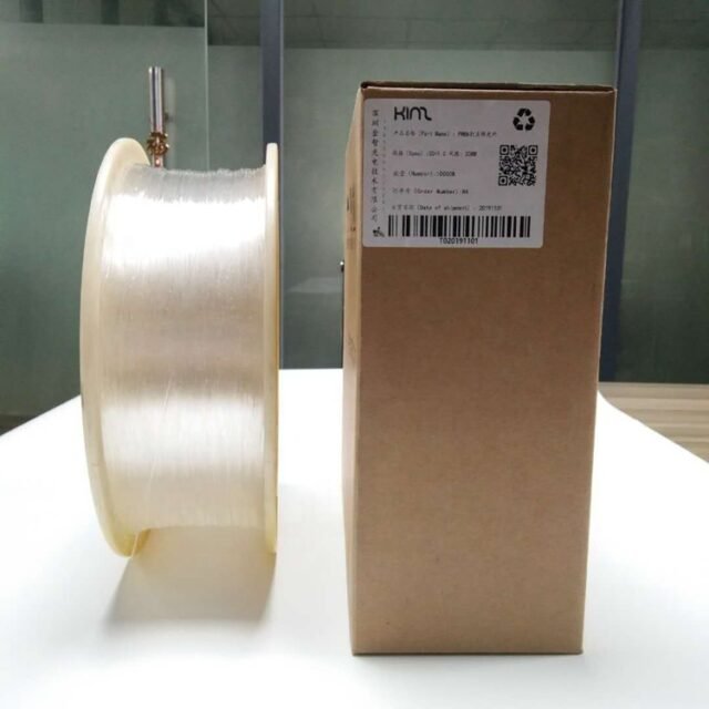 PMMA side-glow fiber on a production spool next to its shipping carton