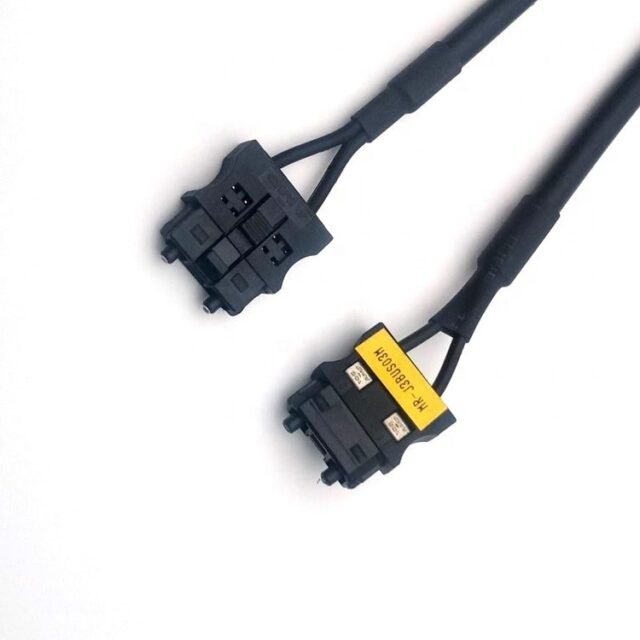 Two black MR-J3BUS03M F07-AMP connectors, one with yellow label, on black cord