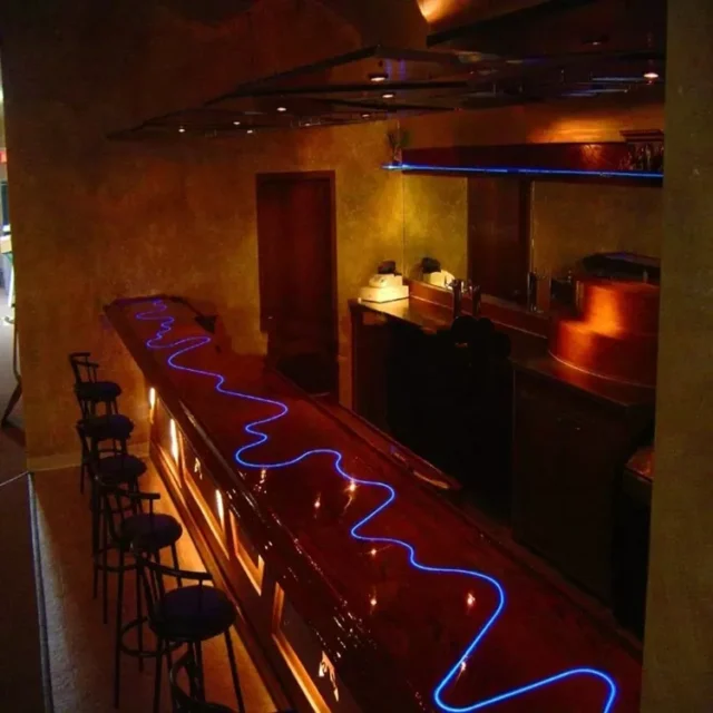 Blue side-glow fiber strip inlaid along a bar counter