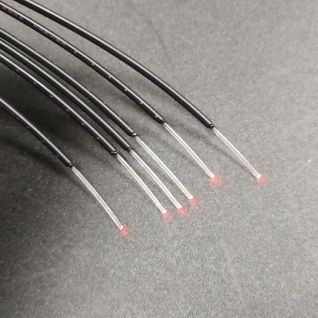 GH-grade POF cables stripped back to clear 1.0mm fiber glowing red at ends