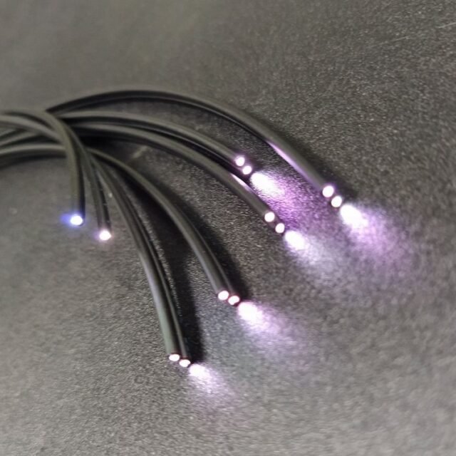 Bundle of black MH/RH-grade POF cables with violet-blue light at the ends