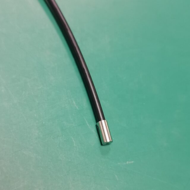 Detail of metal cylindrical ferrule probe end on black PMMA sensor cable